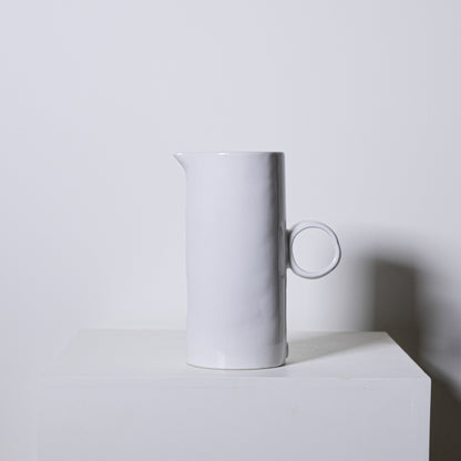 White ceramic fir pitcher no 923 with minimalist cylindrical body and circular handle for serving liquids
