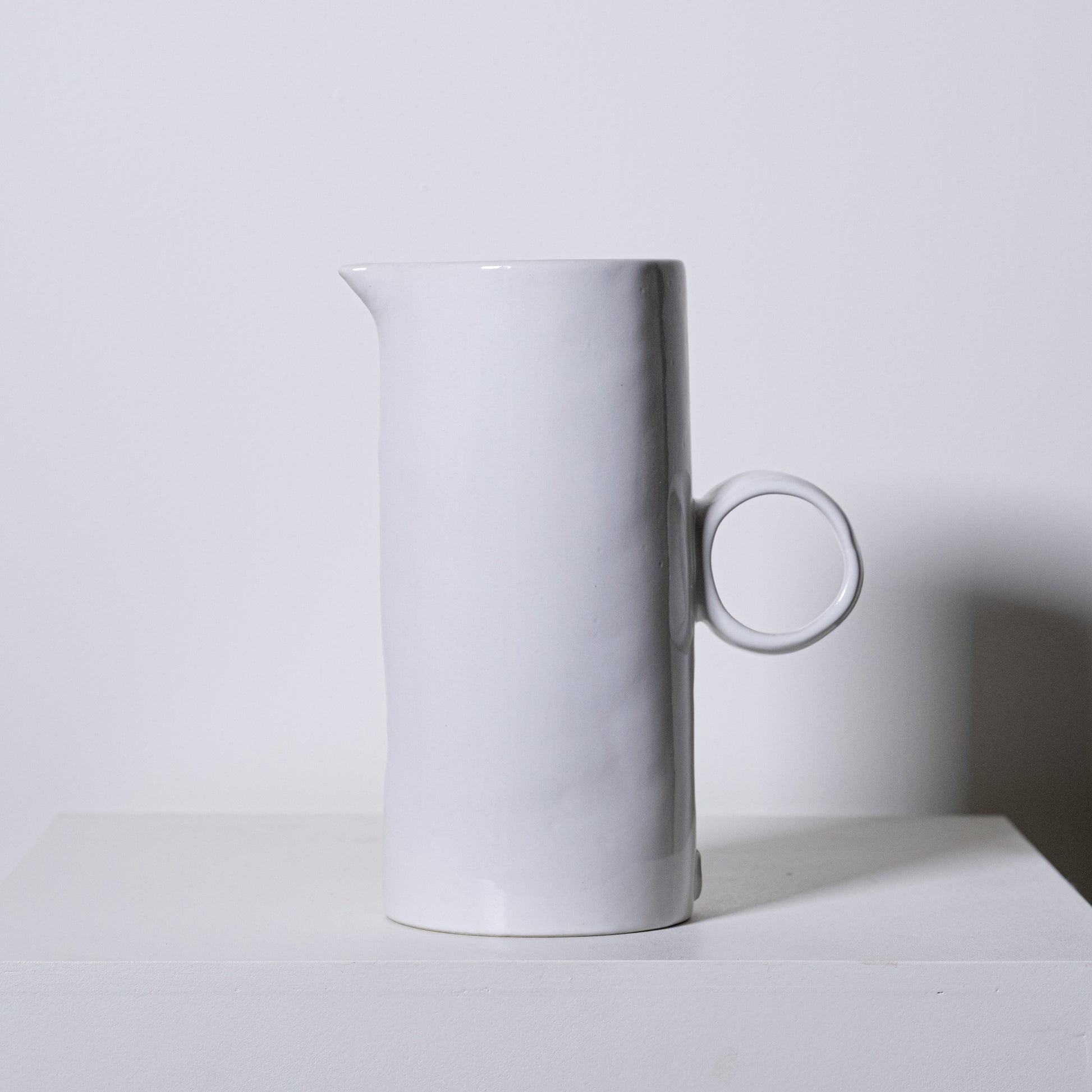 Minimalist white ceramic fir pitcher no 923 with sleek cylindrical body and circular handle for stylish serving