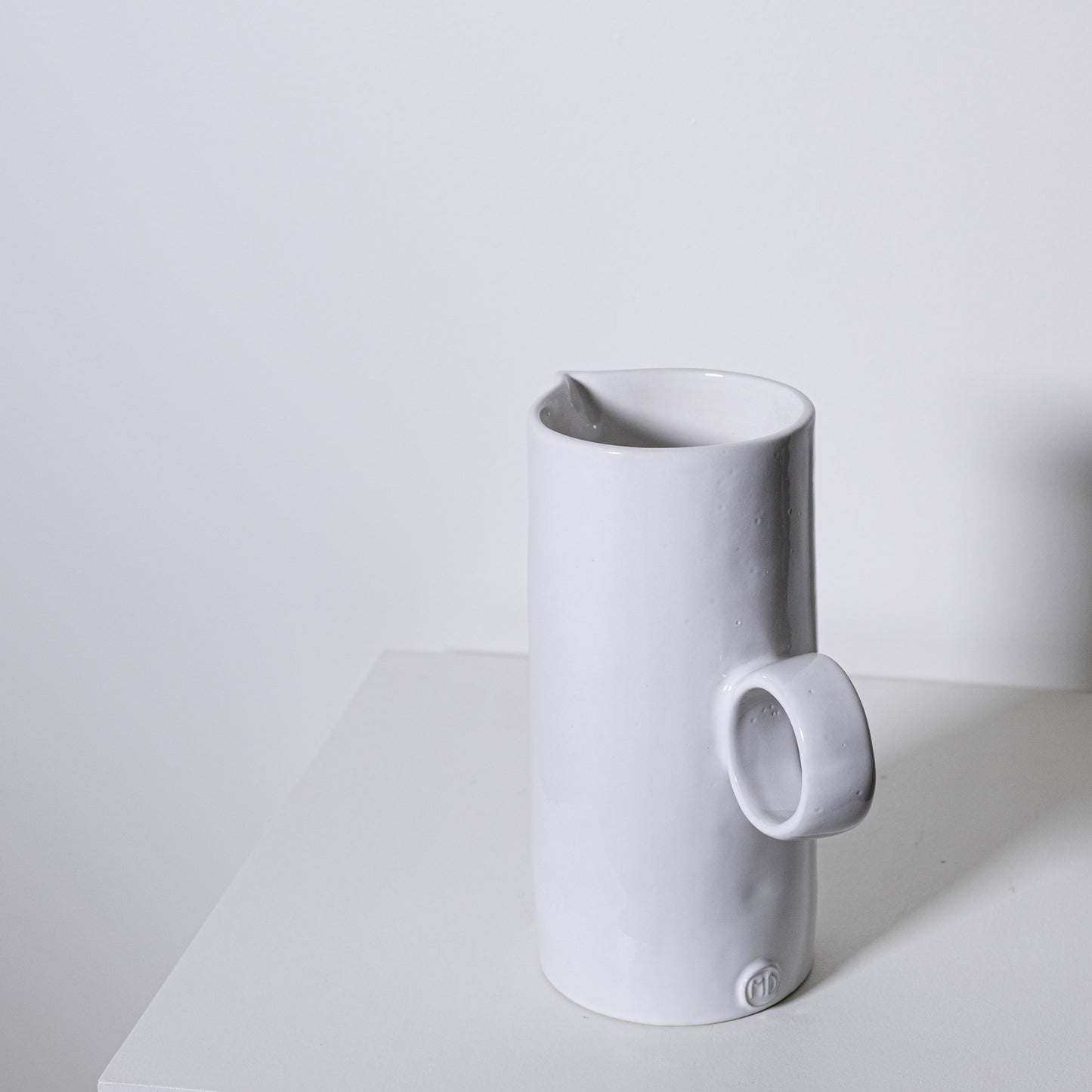 White ceramic fir pitcher no 923 with minimalist design and small circular handle for elegant serving