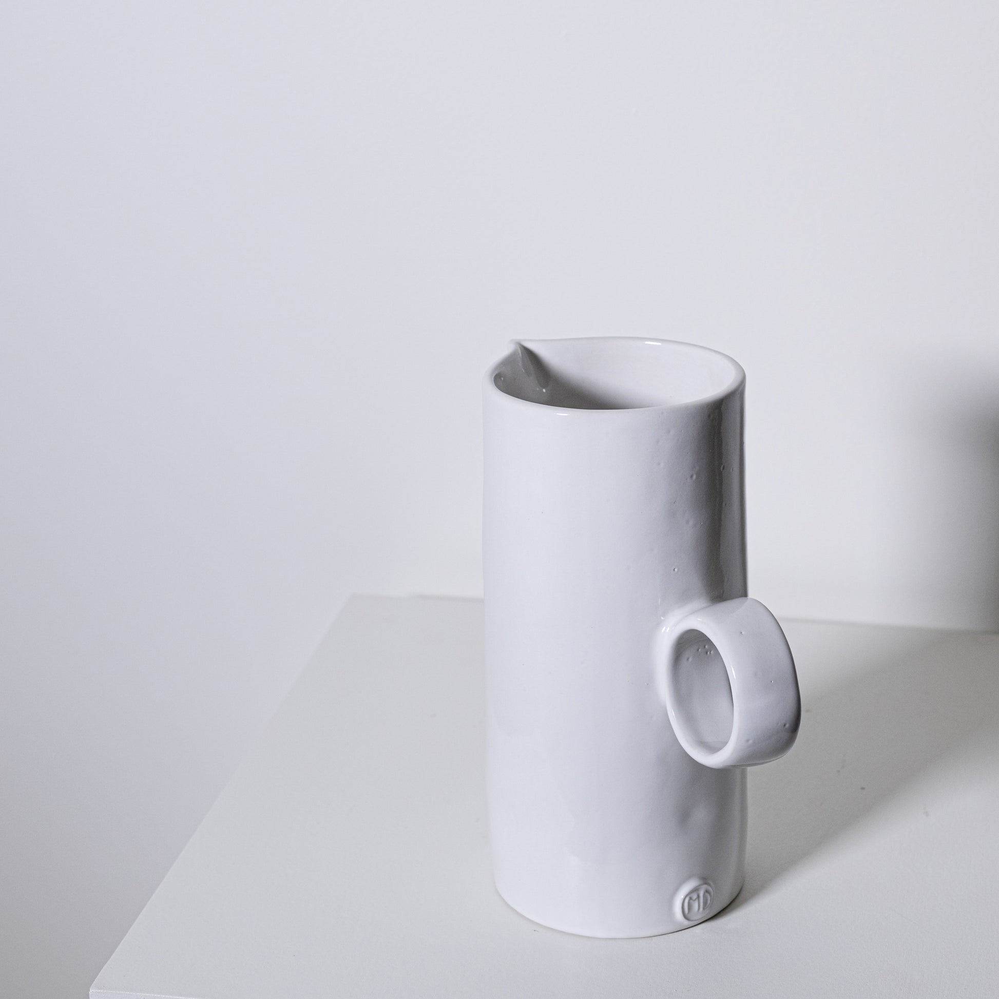 White ceramic fir pitcher no 923 with minimalist design and small circular handle for elegant serving