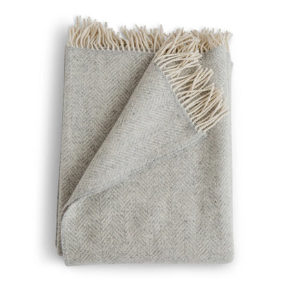 Gray woven blanket with white fringe on a white background