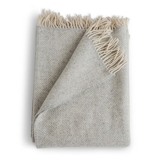 Gray woven blanket with white fringe on a white background