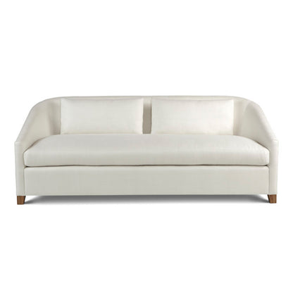 Cream-colored custom order Genevie sofa upholstered with curved arms and wooden legs designed for living rooms