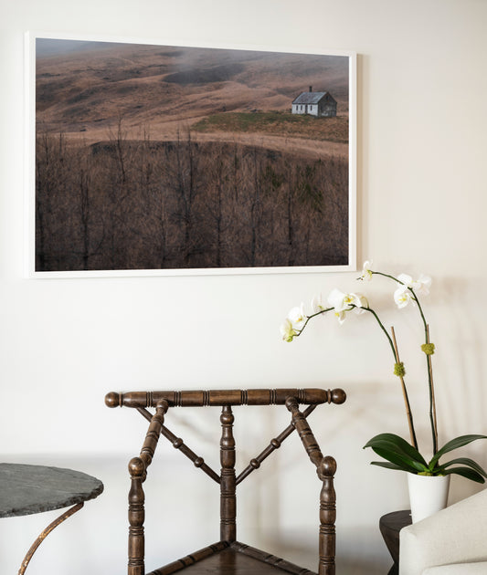 A framed photograph titled house of silence showing a solitary house in a misty brown landscape with bare trees