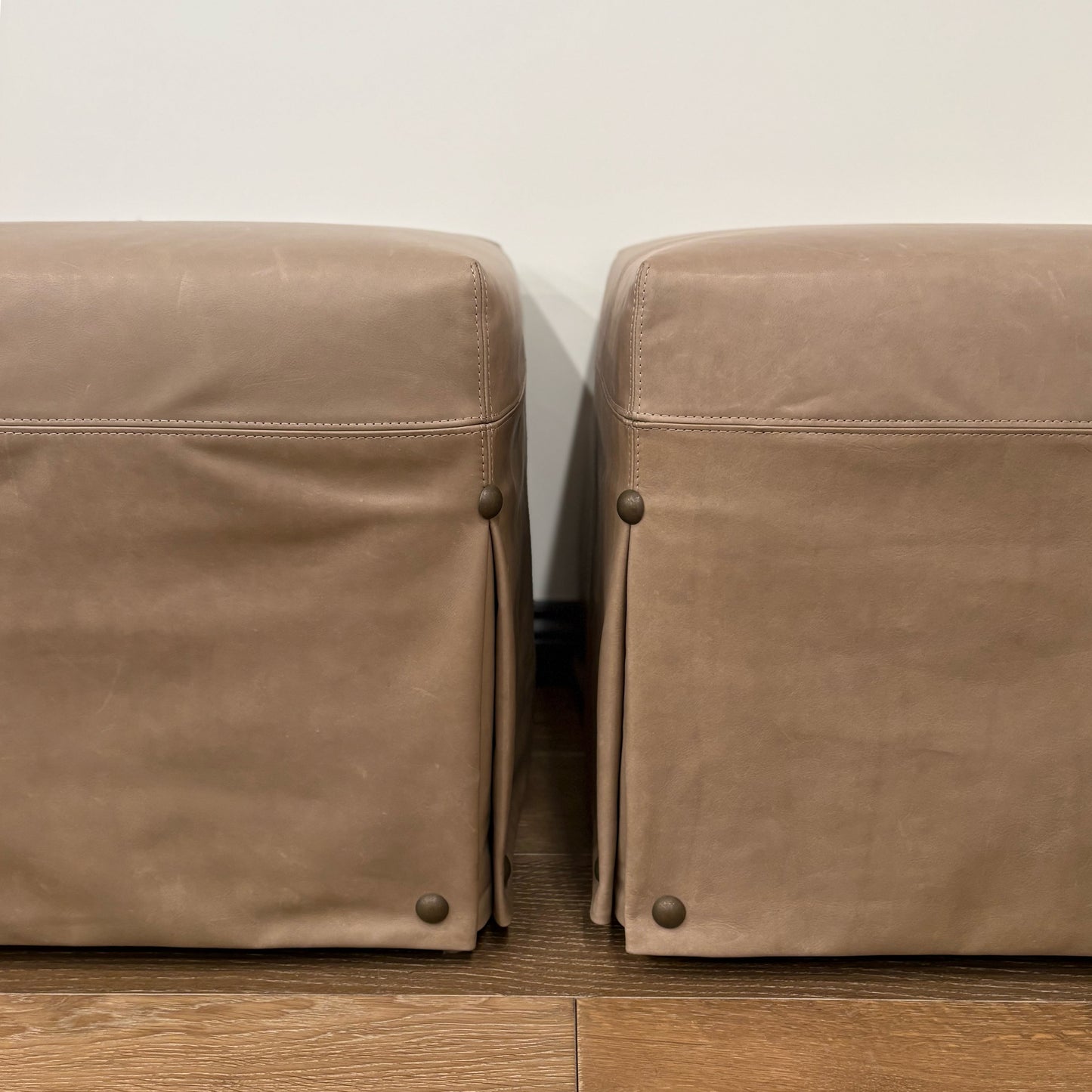 Custom order kim ottoman in tan leather with subtle stitching and brass toned studs at the corners