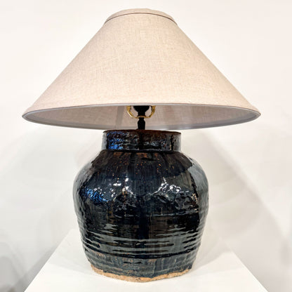 Mid century shanxi glazed pot table lamp with a dark glossy ceramic textured surface and horizontal ridges
