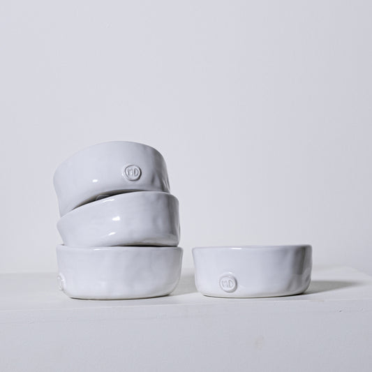 Stack of four minimalist white ceramic linden bowls no 803 with subtle matte finish and embossed logo