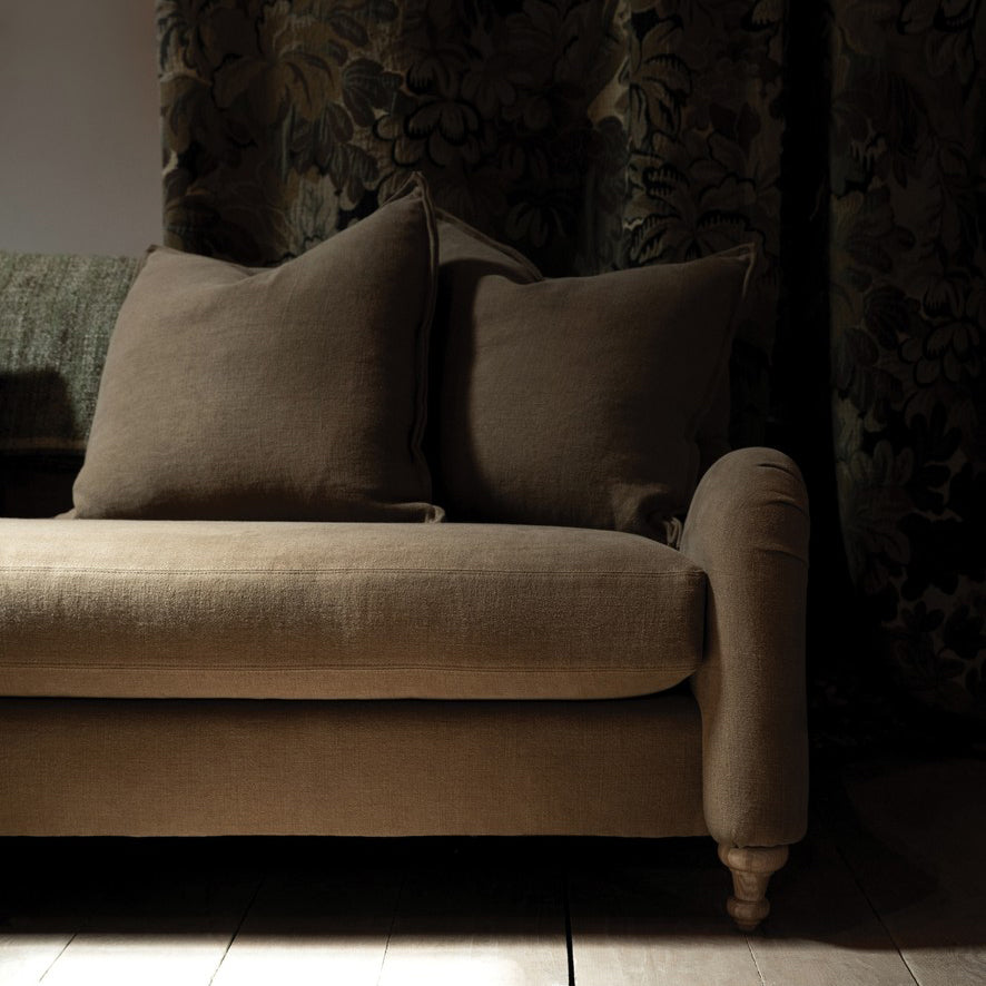 Beige linen custom order margot sofa with rolled arms wooden legs and two matching throw pillows