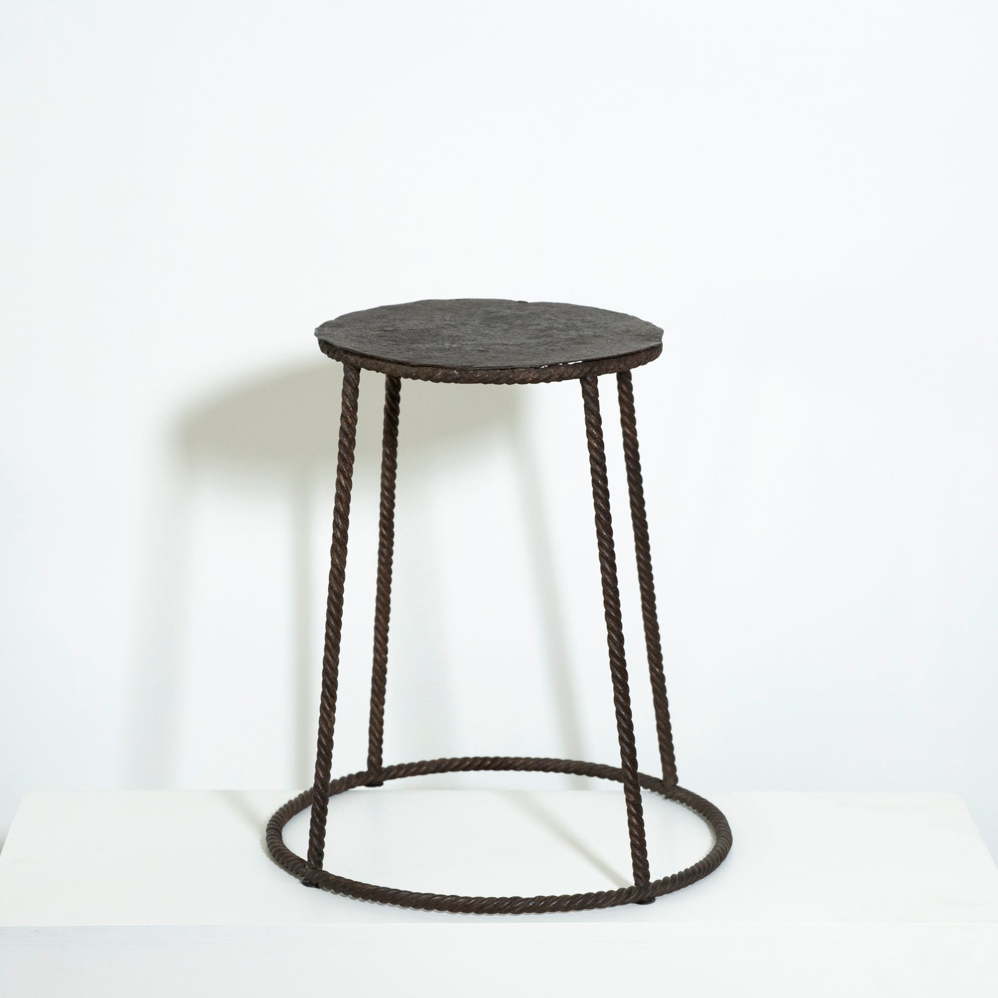 Round stool with black woven design on a white background