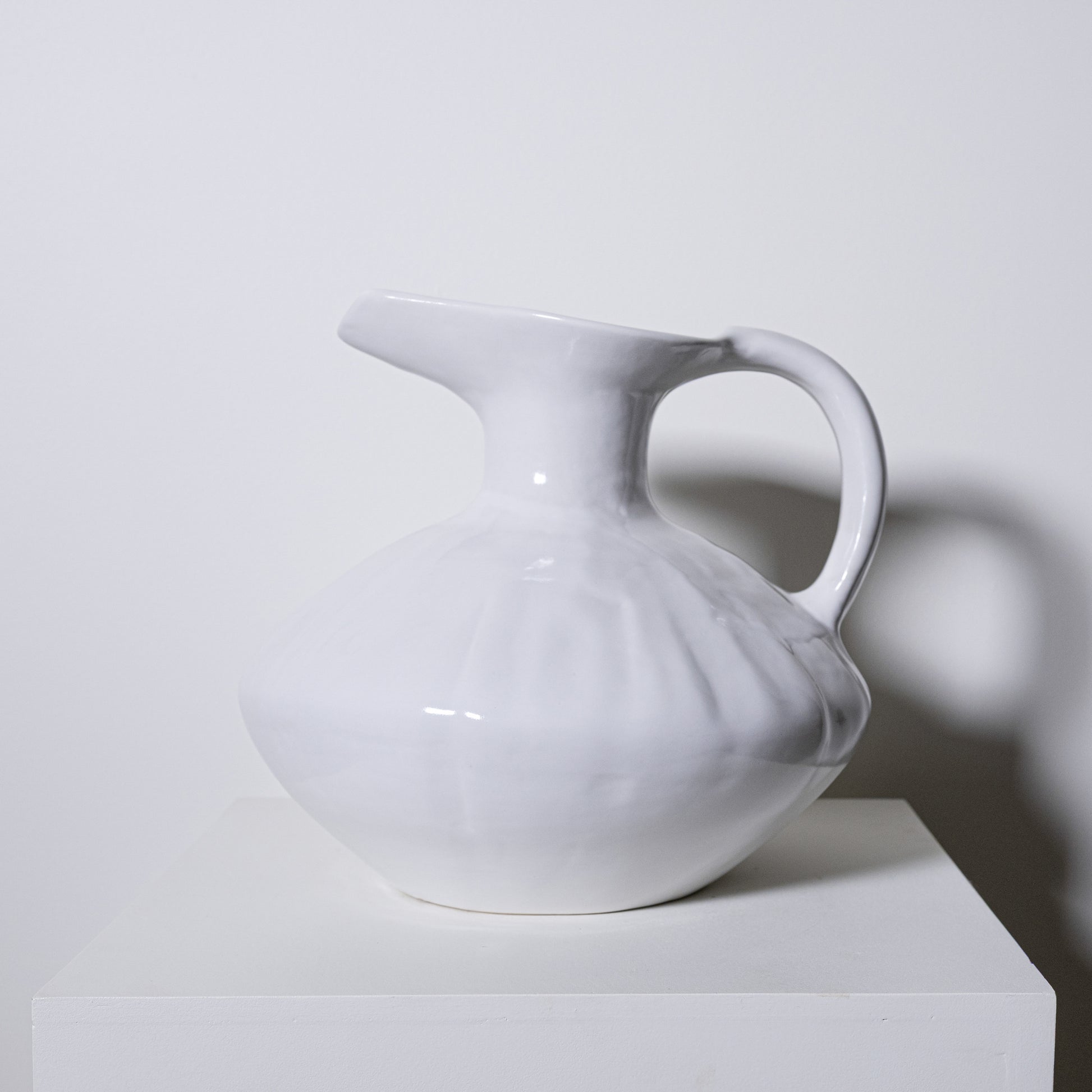 White ceramic oak pitcher no 431 with a glossy finish and subtle vertical ridges ideal for serving beverages