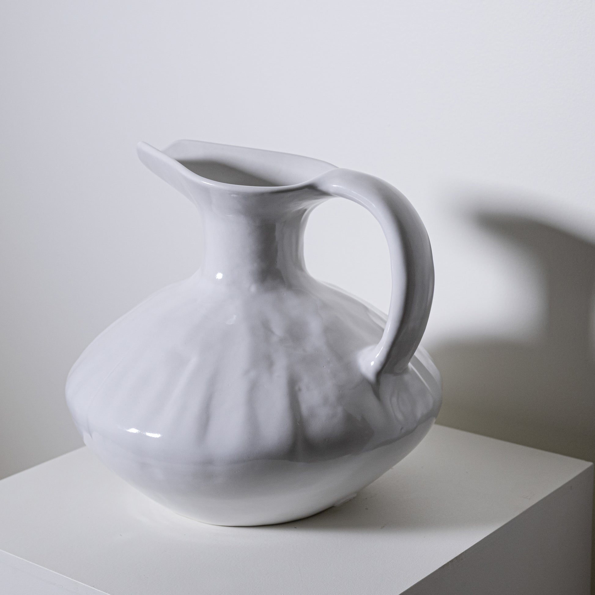 A white ceramic oak pitcher no 431 with a fluted textured body and smooth handle for serving liquids