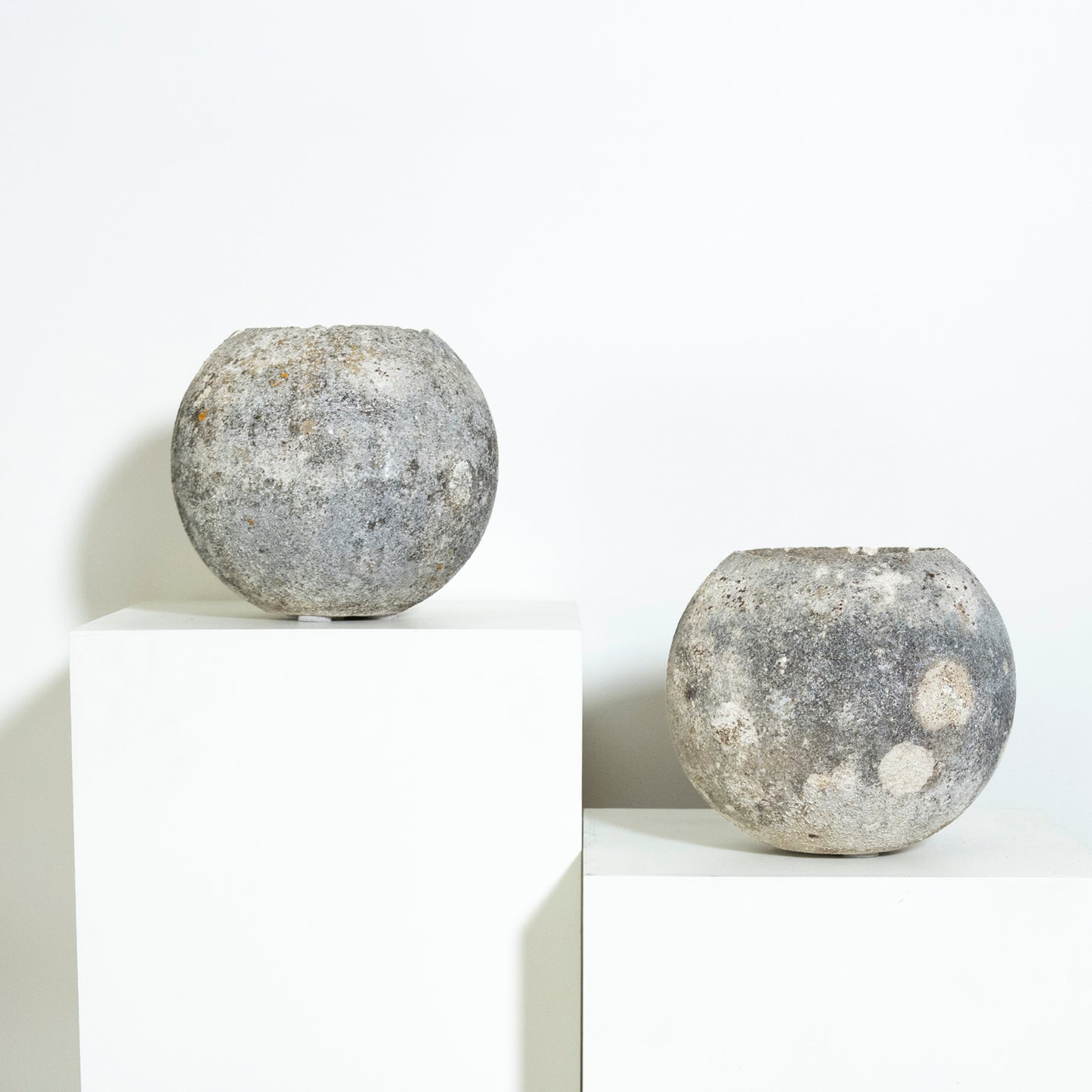 Two spherical concrete objects on a white background