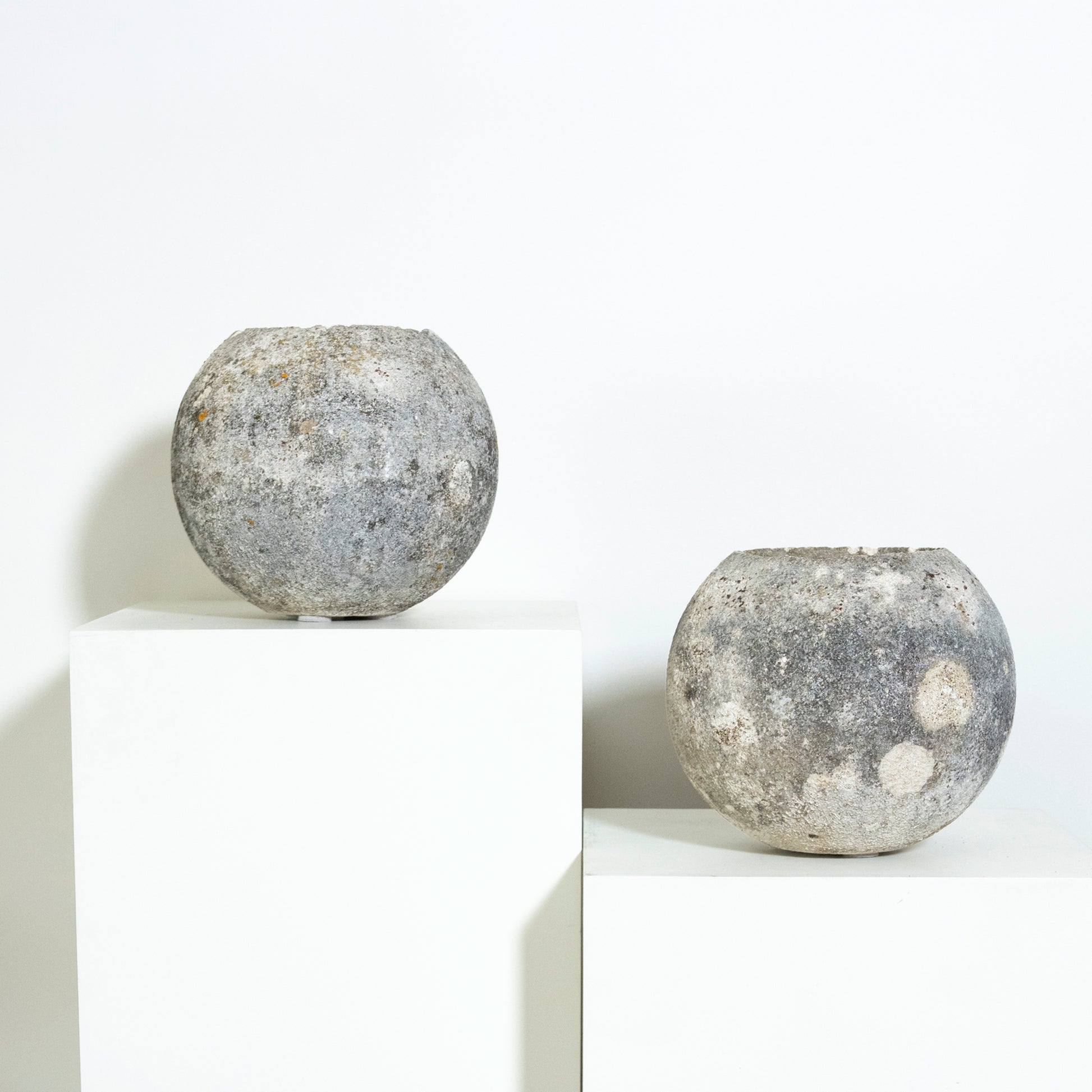 Two spherical concrete objects on a white background