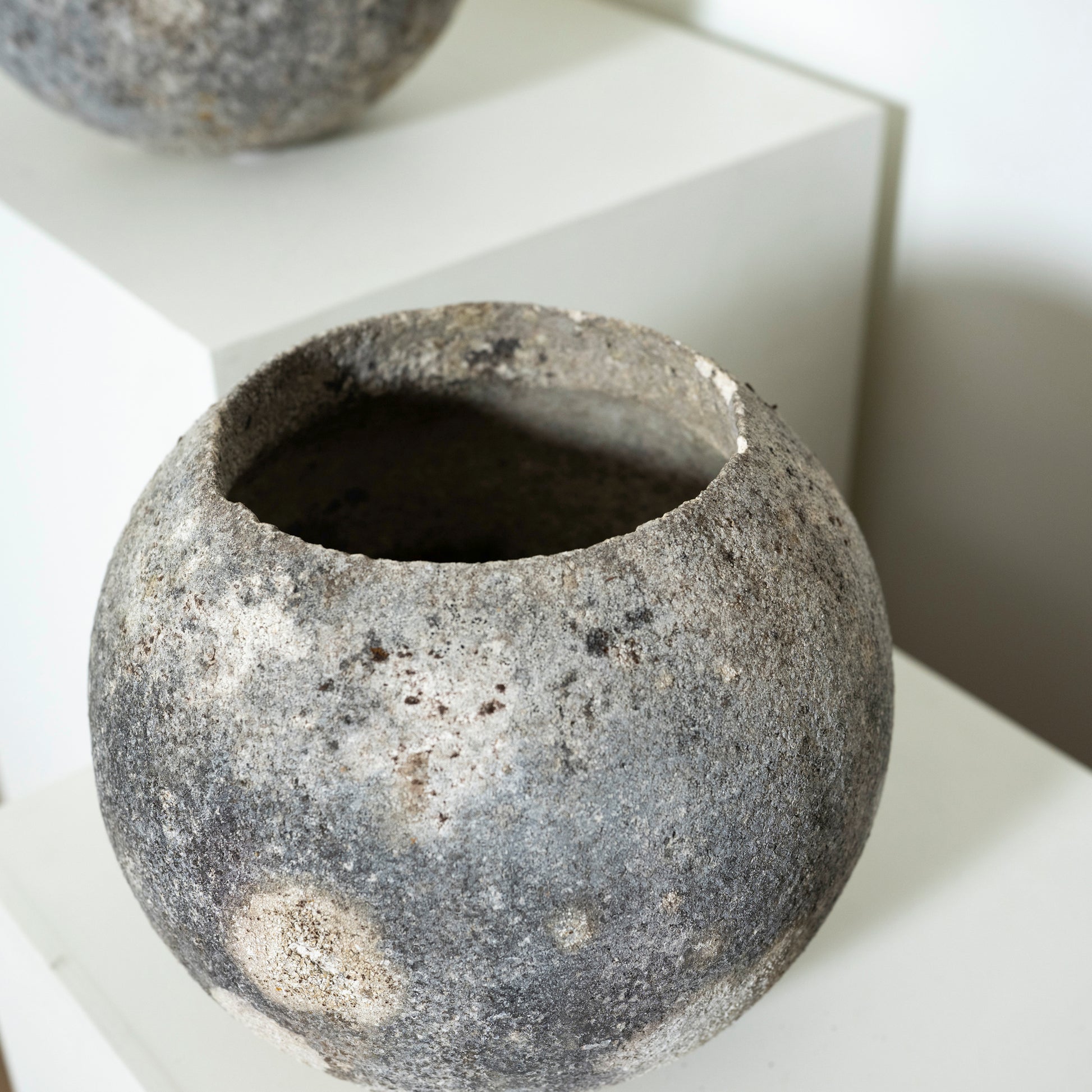Textured stone-like pot on a white surface