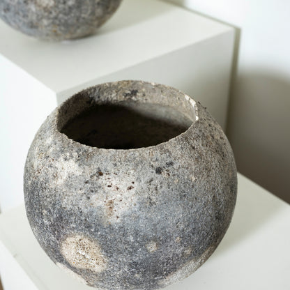 Textured stone-like pot on a white surface