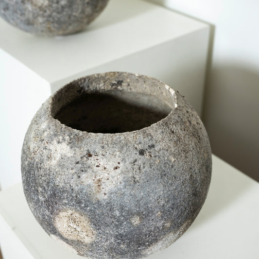 Textured stone-like pot on a white surface