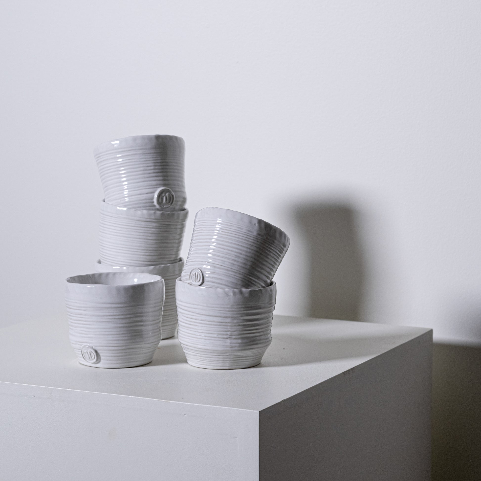 White ceramic pine tumblers no 79 with vertical ribbed texture and subtle circular logo on the side