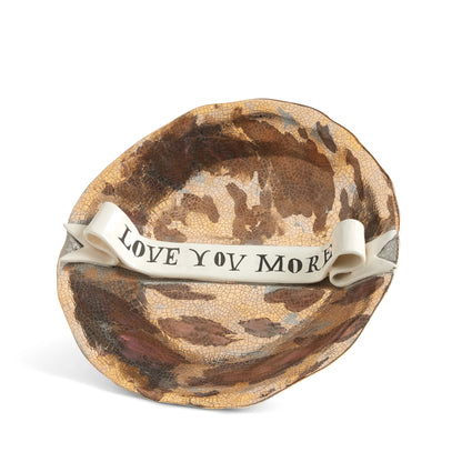 Brown crackled ceramic bowl with a white ribbon reading love you more from Ruan Hoffman collection