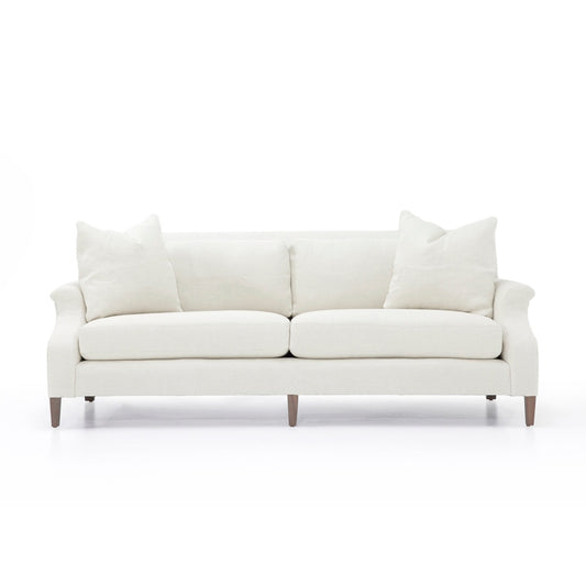 Cream-colored custom order Rafael sofa with rolled arms upholstered in fabric and wooden legs