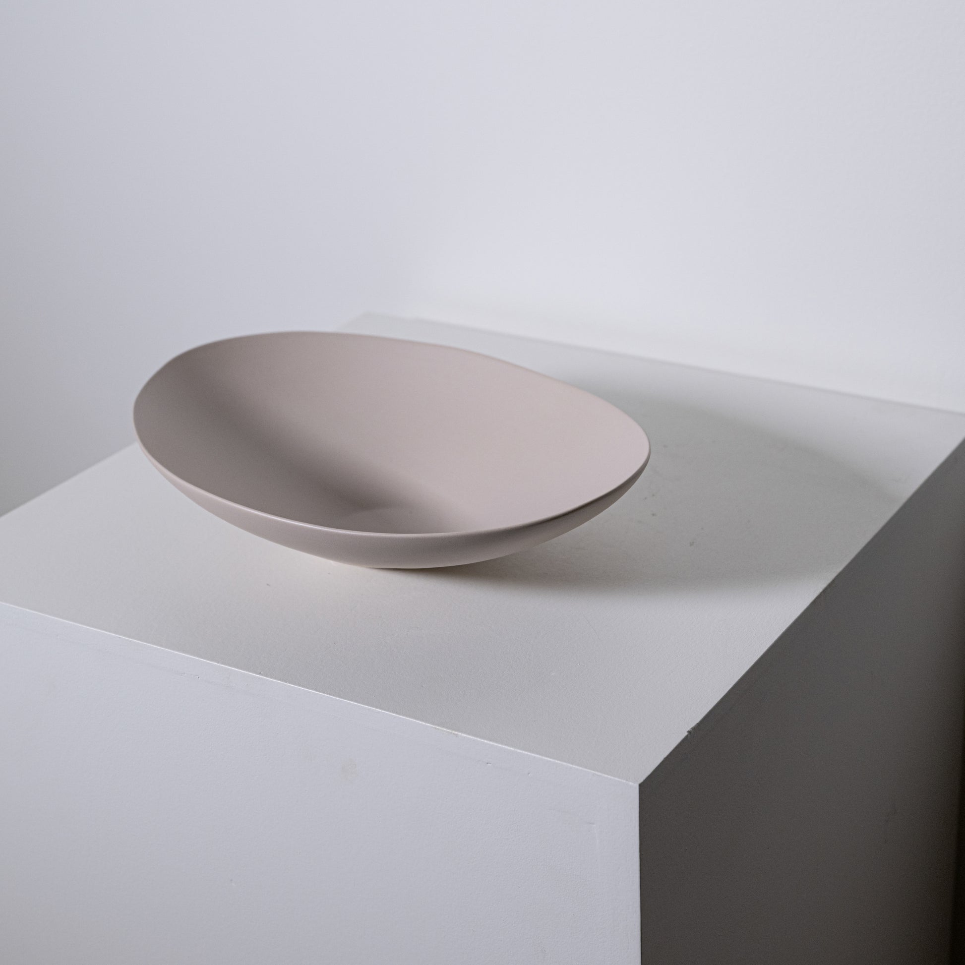 A sleek matte-finished beige oval vessel sink with smooth curves and minimalist design called Baccello Small Greige