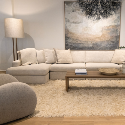 Beige sectional sofa with plush textured upholstery and matching throw pillows featured with custom order menorca coffee table