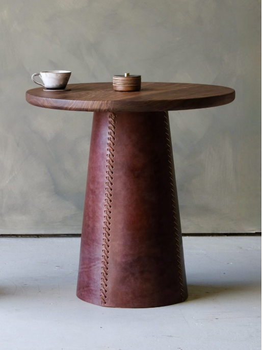 Taper side table with a sleek dark brown wooden top and conical leather base featuring decorative stitching