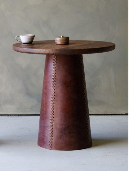 Taper side table with a sleek dark brown wooden top and conical leather base featuring decorative stitching