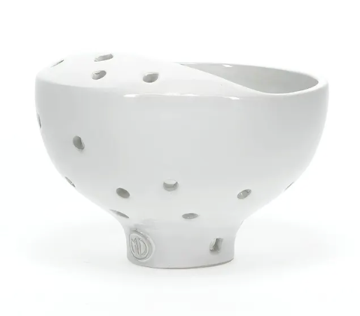 White ceramic bowl with decorative cutouts on a white background