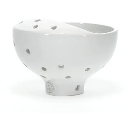 White ceramic bowl with decorative cutouts on a white background
