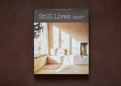 A hardcover book titled still lives with a minimalist beige and white cover featuring an interior scene in natural light