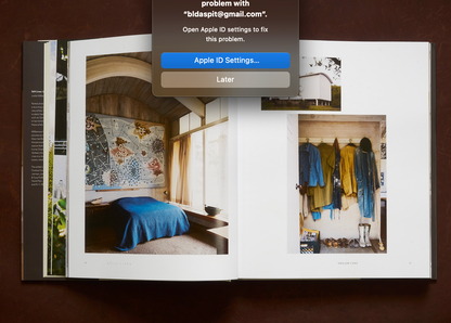 An open hardcover book still lives displaying interior design photographs in the homes of artists great and unsung