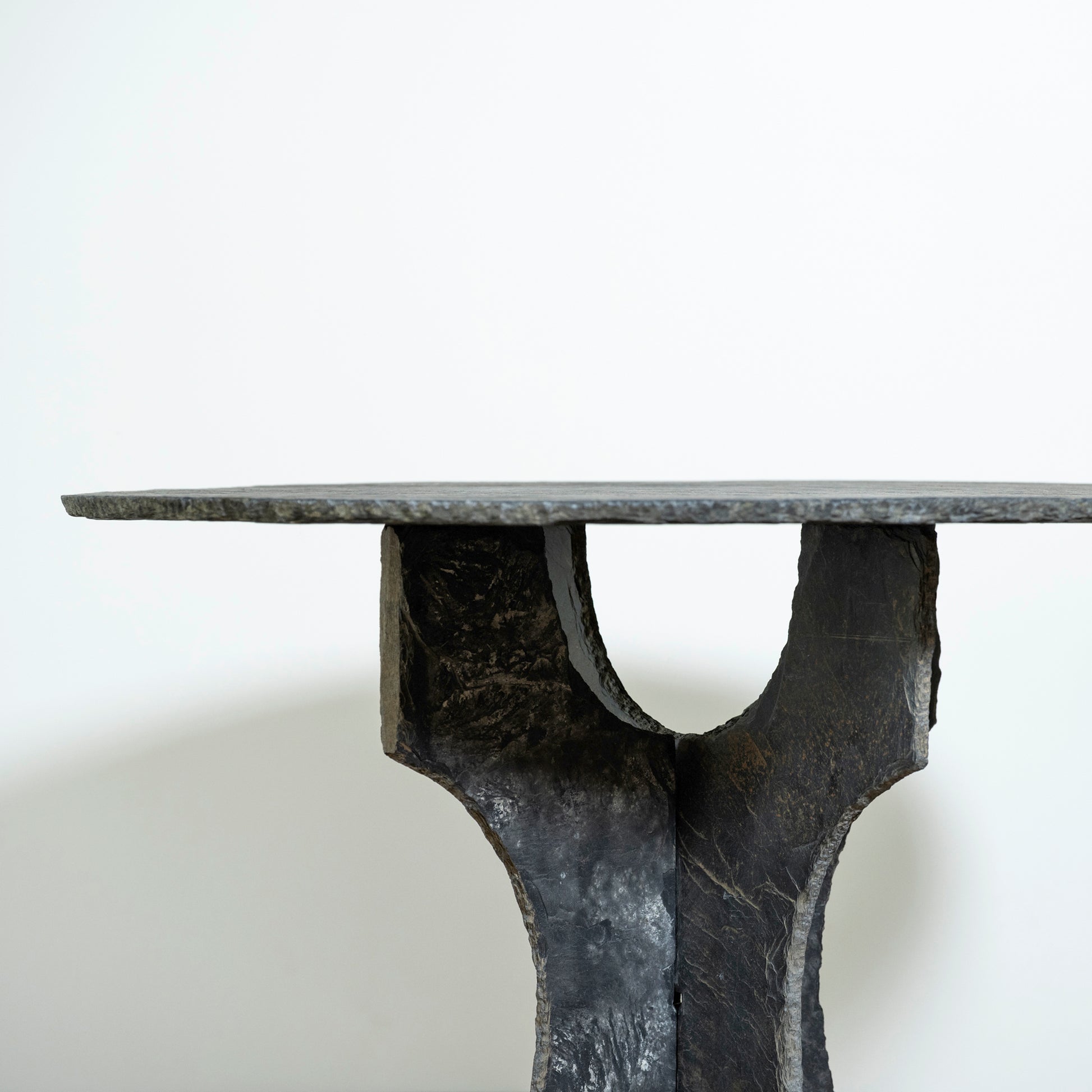 Black metal table with a unique base design on a white background