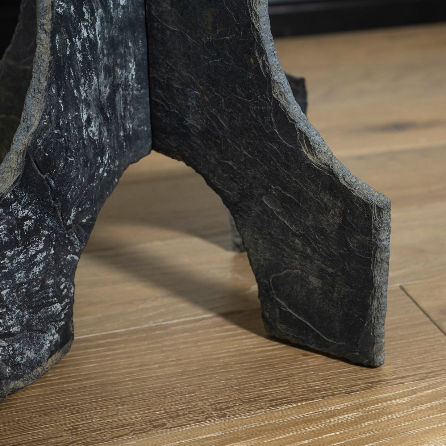 Close-up of textured black shoes on a wooden floor