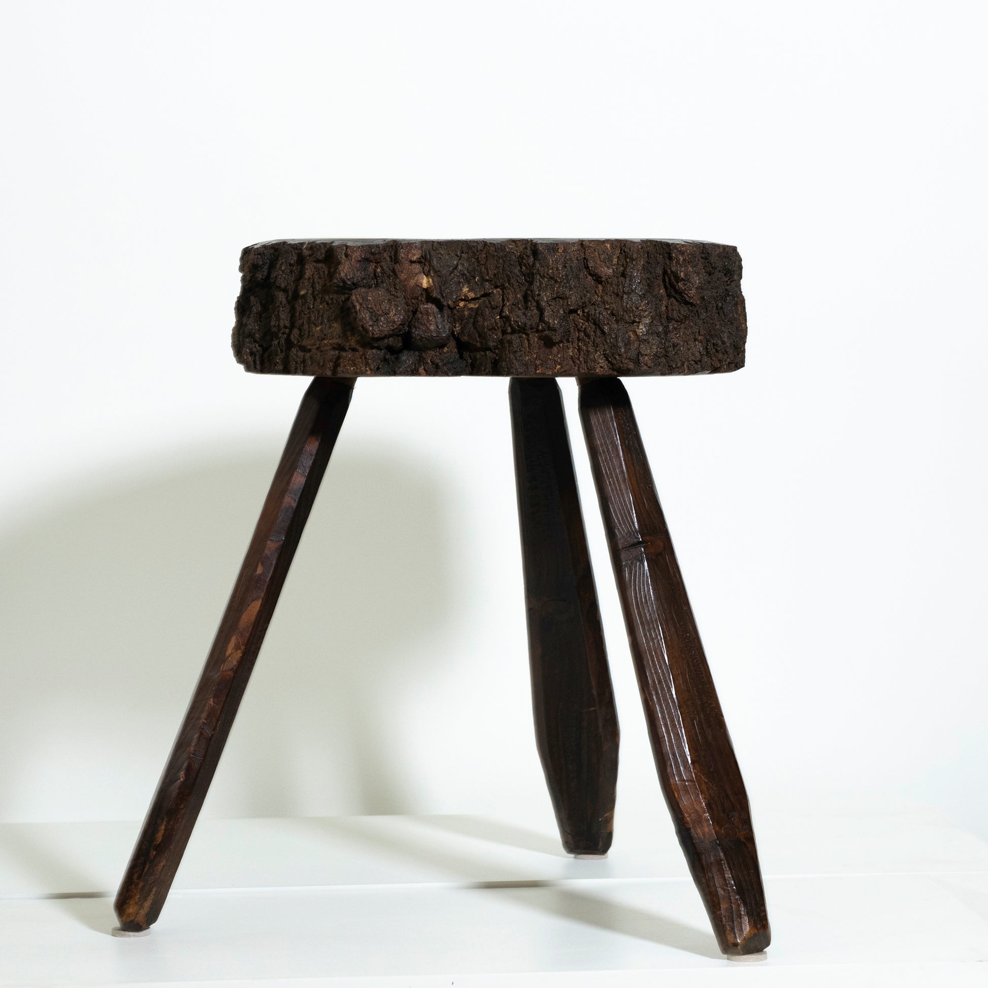 Wooden stool with a round top and three legs on a white background