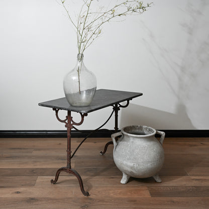 A clear glass mid century willy ghul marmite cauldron vase with a bulbous body and narrow neck holding green branches