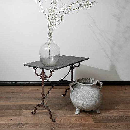 A clear glass mid century willy ghul marmite cauldron vase with a bulbous body and narrow neck holding green branches