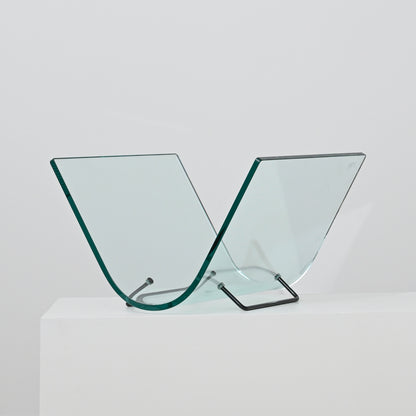 The Vintage Italian Curved Glass Magazine Holder features two V-shaped curved glass panels with a sleek metal stand, displayed on a white surface against a plain background.