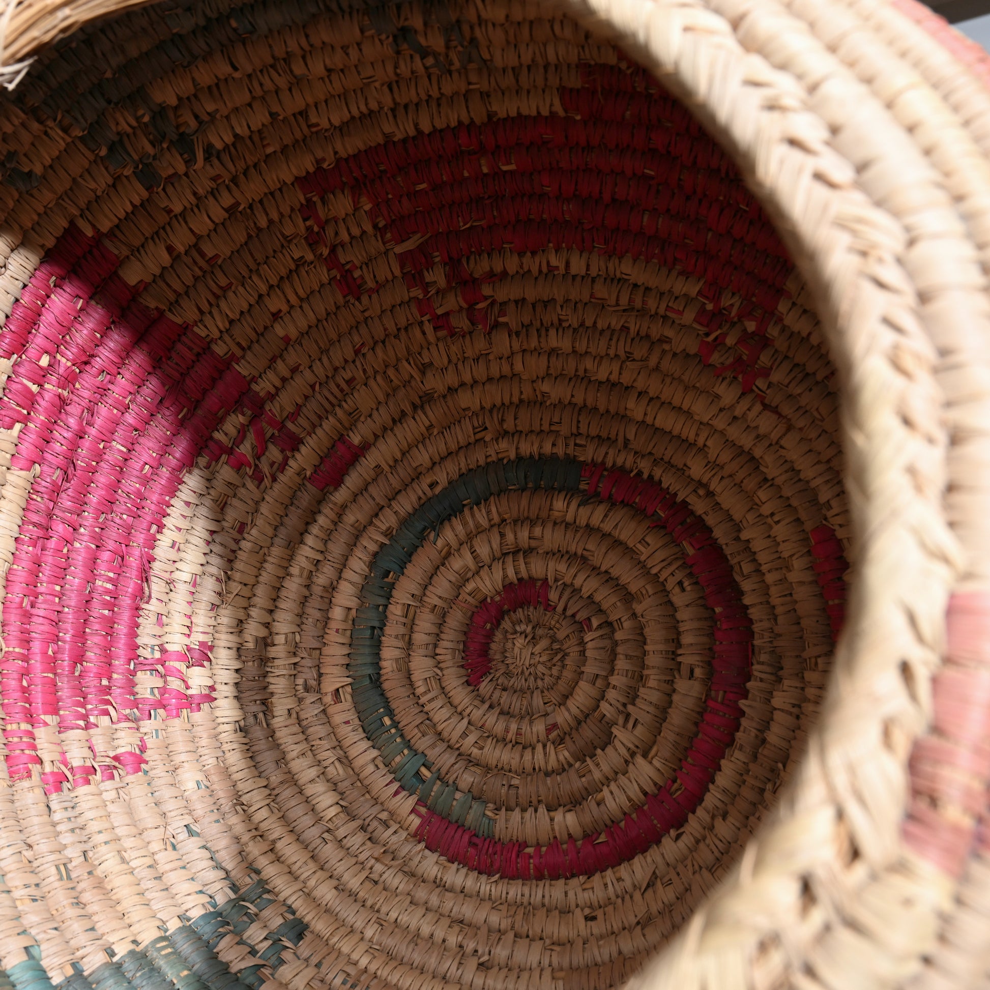 Mid 20th century Native American handwoven basket with spiral pattern in beige pink and teal stripes