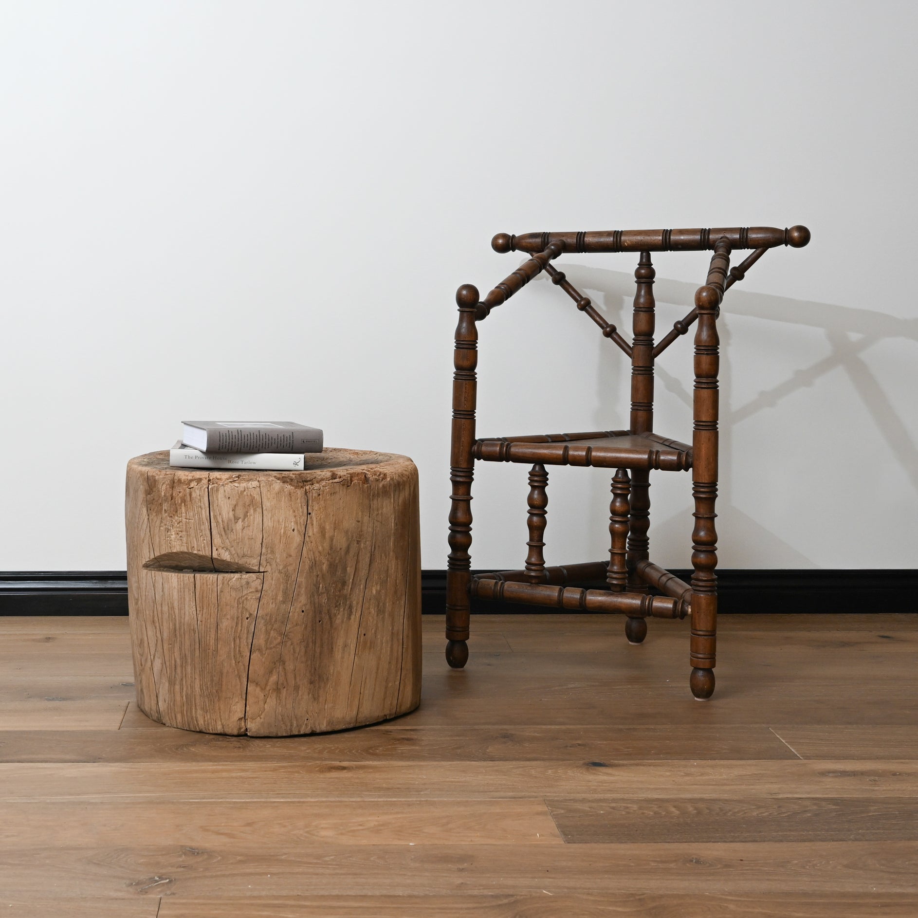Antique dark wood wishbone chair with turned spindles and classic design beside late 19th century japanese mortar table