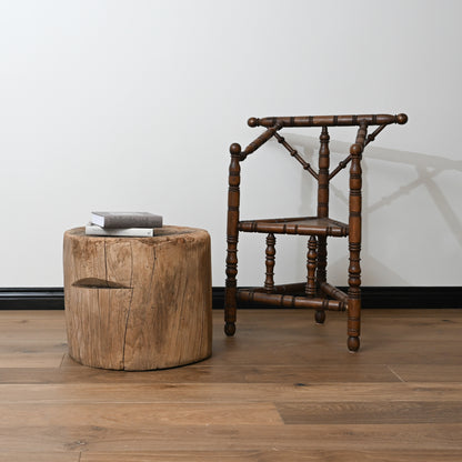Antique dark wood wishbone chair with turned spindles and classic design beside late 19th century japanese mortar table