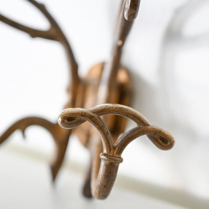 Close-up of the Antique French Bronze Hook featuring multiple curved arms, inspired by 1930s French decor, wall-mounted against a blurred white background.