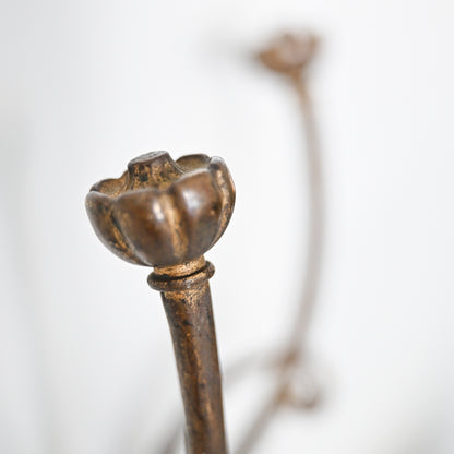 Close-up of the Antique French Bronze Hook, designed as a decorative floral knob reminiscent of 1930s French decor, with a softly blurred similar floral motif in the background.