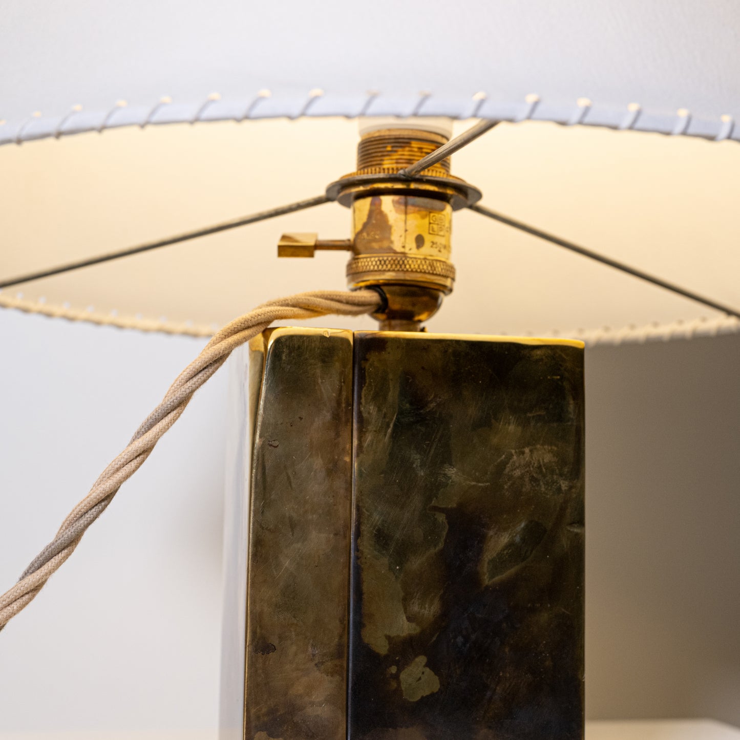 Brass and parchment table lamp with a rectangular brass base in dark patinated finish and textured surface