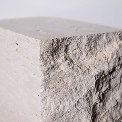 Travertine block side table with a textured light gray stone pillar featuring a rough natural surface and subtle veining