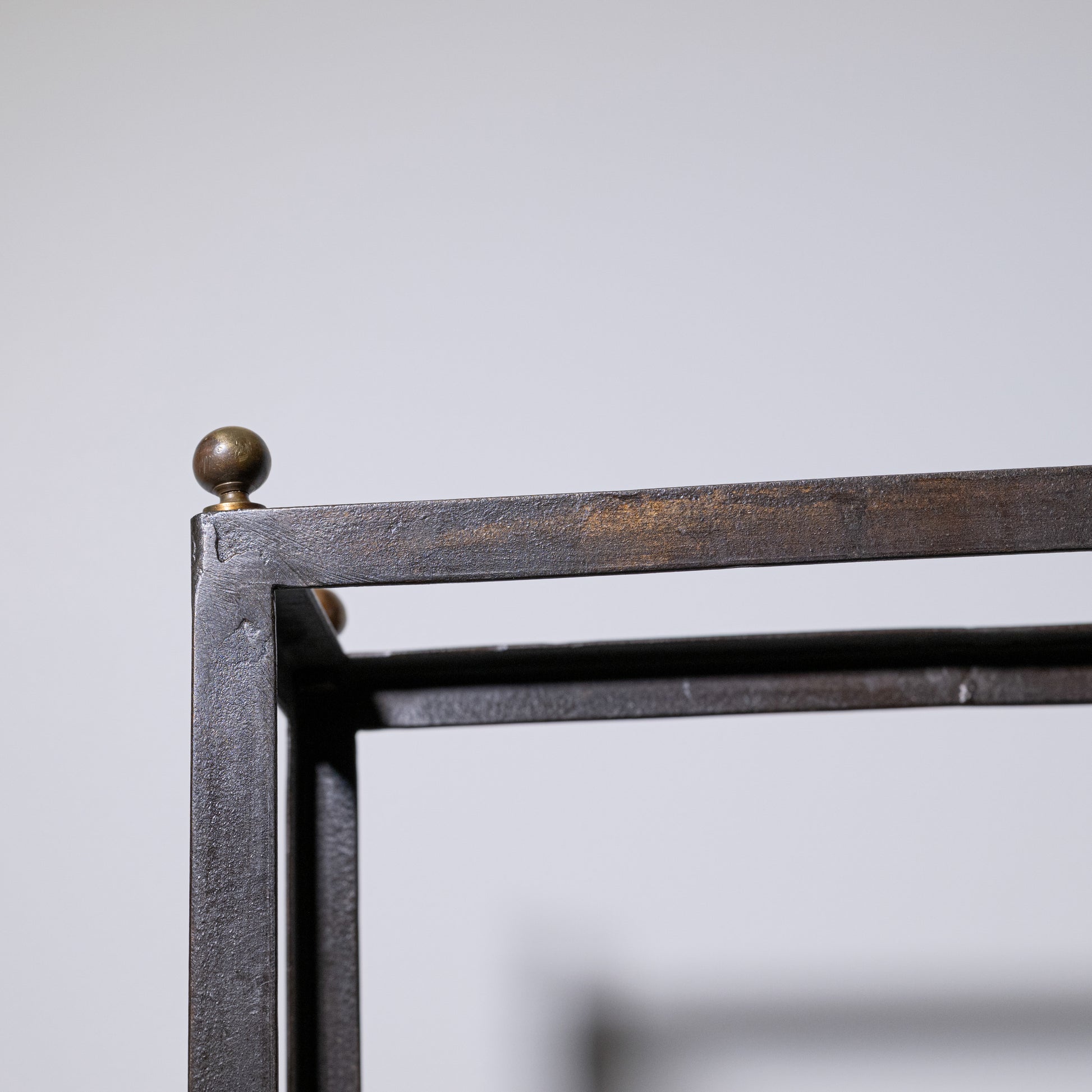 Antique umbrella stand with a dark metal frame matte finish and brass-colored spherical finials at the corners