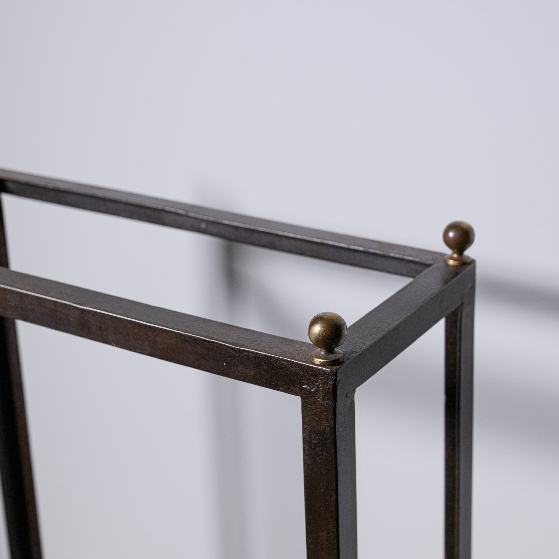 Antique umbrella stand made of dark bronze metal with spherical finials at each corner for elegant storage