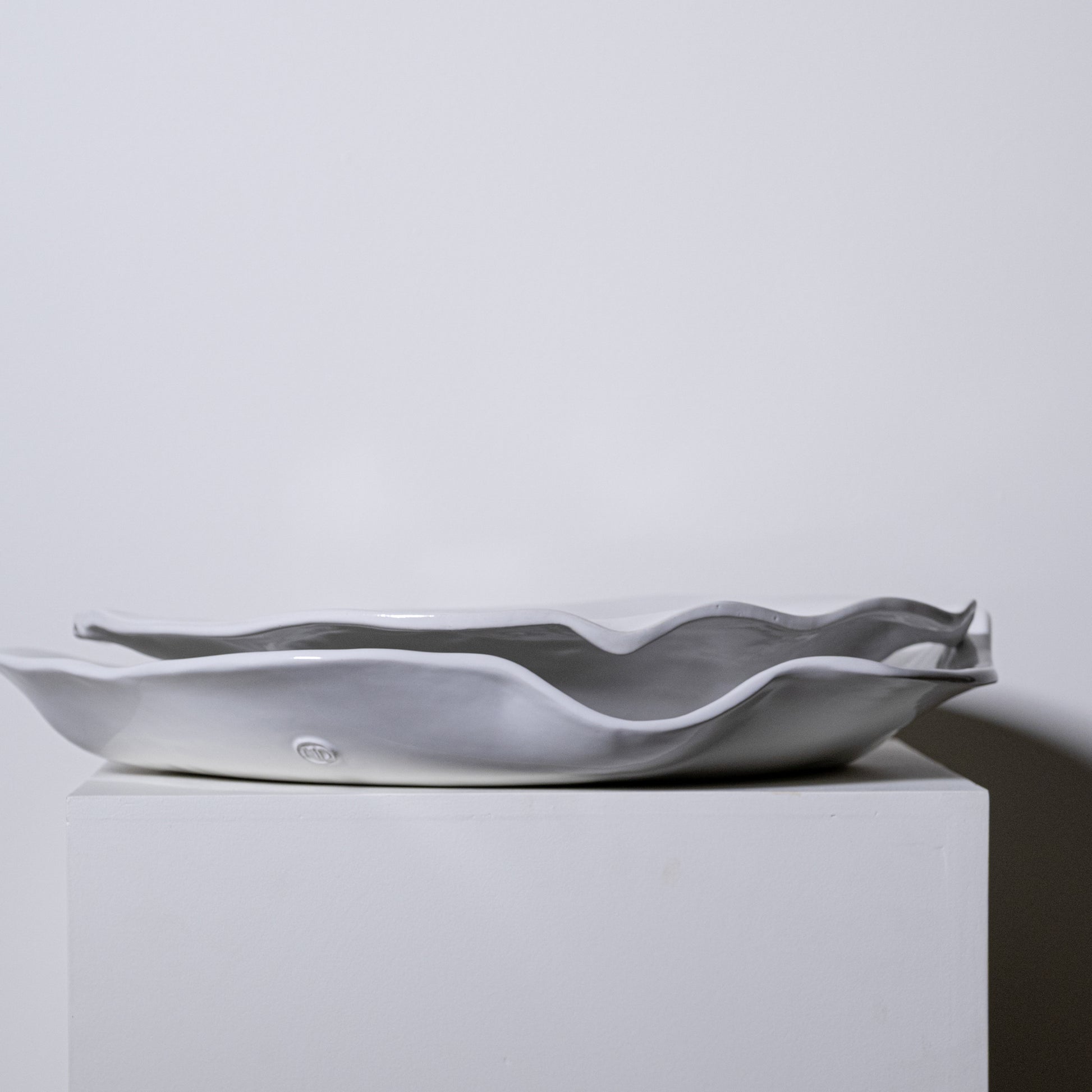 A sleek matte gray ceramic serving dish with wavy organic edges named Aspen Platter No 723