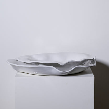 A sleek white ceramic sink with a wavy organic edge design in the Cyprus Platter No 724 collection