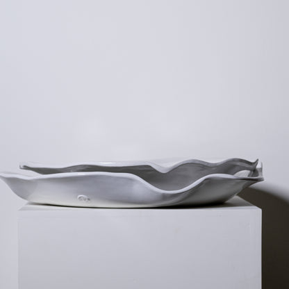 A sleek matte gray ceramic serving dish with wavy organic edges called Cyprus Platter No 724