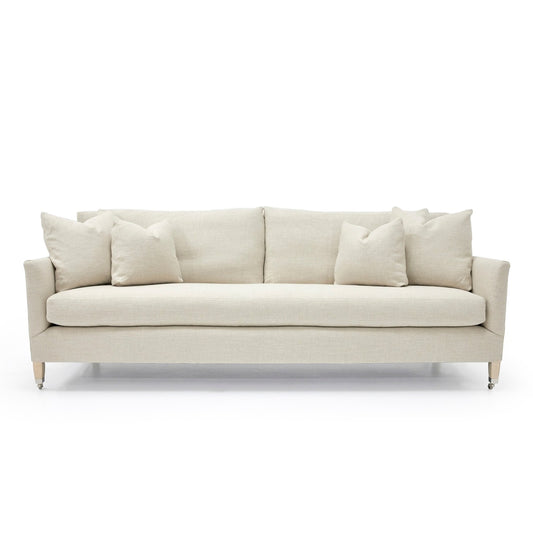 Beige upholstered custom order victor sofa with clean lines and matching throw pillows for modern living rooms